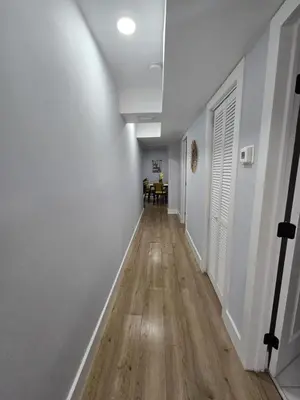 an empty hallway with white walls and wooden floors at Miami Urban Oasis - B in Miami