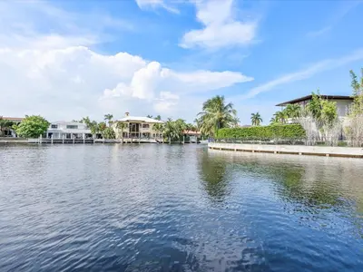 a large body of water with houses and palm trees at luxury house by the water in Eastern Shores