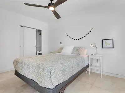 a bedroom with a bed and a ceiling fan at luxury house by the water in Eastern Shores