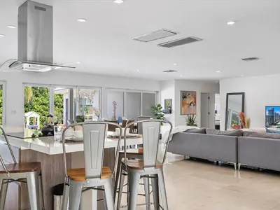 a kitchen and living room with a table and chairs at luxury house by the water in Eastern Shores