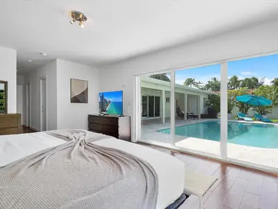 a bedroom with a large bed and a swimming pool at luxury house by the water in Eastern Shores