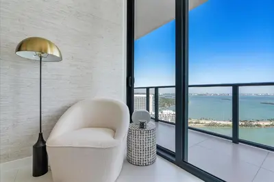 a living room with a chair and a floor to ceiling window at POSH Ocean View Penthouse - Heated Pool, Gym, Office! 10mins Beach in Miami