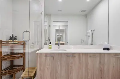 a white bathroom with a sink and a shower at POSH Ocean View Penthouse - Heated Pool, Gym, Office! 10mins Beach in Miami