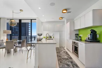 a kitchen with a table and a dining room with a view at POSH Ocean View Penthouse - Heated Pool, Gym, Office! 10mins Beach in Miami