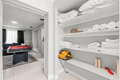 a walk in closet with a pool table and towels at Fort Lauderdale Retreat Near Beach & Airport in Fort Lauderdale