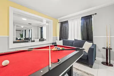 a pool table in a living room with a mirror at Fort Lauderdale Retreat Near Beach & Airport in Fort Lauderdale