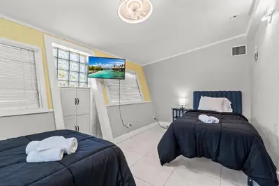 a bedroom with two beds and a flat screen tv at Fort Lauderdale Retreat Near Beach & Airport in Fort Lauderdale