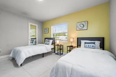 two beds in a room with yellow walls at Fort Lauderdale Retreat Near Beach & Airport in Fort Lauderdale