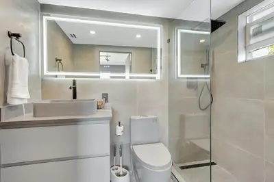 a bathroom with a sink and a toilet and a mirror at Newly Renovated 1BR Condo Near South Beach in Miami Beach