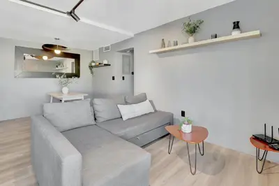a living room with a gray couch and a table at Newly Renovated 1BR Condo Near South Beach in Miami Beach