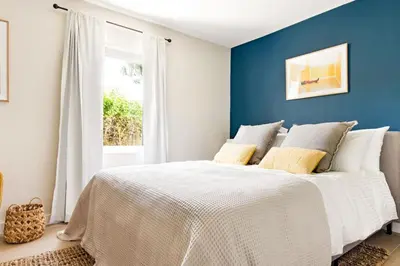 a bedroom with a white bed with a blue wall at Lux 6BR Villa with Pool, King Beds and Top Amenities in Miami
