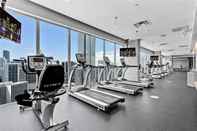 a gym with rows of tread machines in a building at Luxury Loft 270 views, Rooftop Pool, Parking in Miami