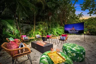 a patio with chairs and a tv with a screen at Beach Estate Las Olas Beach Best Location in Fort Lauderdale