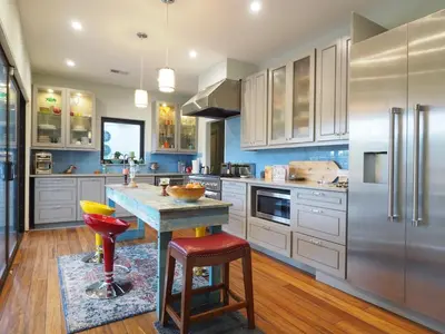 a kitchen with white cabinets and a island with a red stool at Beach Estate Las Olas Beach Best Location in Fort Lauderdale