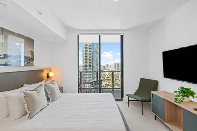 a white bedroom with a bed and a flat screen tv at Stunning Views Dwntwn Miami 2BR Unit - Floor 28th in Miami