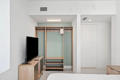 a bedroom with a flat screen tv and a closet at Stunning Views Dwntwn Miami 2BR Unit - Floor 28th in Miami