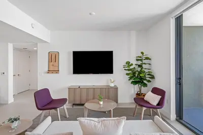 a living room with a tv and purple chairs at Stunning Views Dwntwn Miami 2BR Unit - Floor 28th in Miami