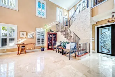 a living room with a staircase and a table and chairs at 5BR Luxury Mins to Las Olas, Shops and Beach in Fort Lauderdale