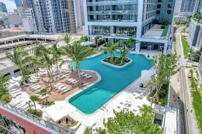 an aerial view of a resort pool with palm trees at Stylish Studio - Amazing Amenities & Pool in Miami