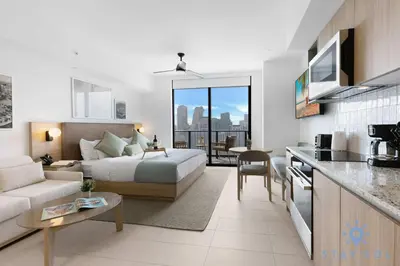 a bedroom and living room with a bed and a kitchen at Stylish Studio - Amazing Amenities & Pool in Miami