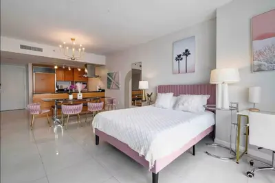 a bedroom with a large bed and a kitchen at Icon Brickell Amazing Ocean View in Miami
