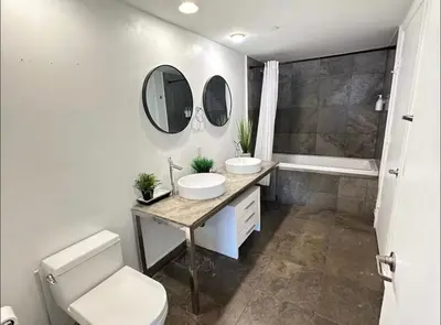 a bathroom with two sinks and a toilet and a tub at Icon Brickell Amazing Ocean View in Miami