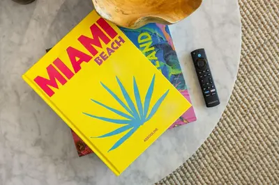 a magazine sitting on a table with a remote control at On The 49th Floor! Condo on Highest & Free Parking in Miami