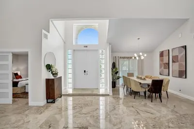 a dining room and living room with a dining table at The Grand Luxe 8BR Villa w POOL and basketball in Pembroke Pines