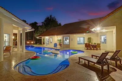 a swimming pool in the middle of a house at The Grand Luxe 8BR Villa w POOL and basketball in Pembroke Pines