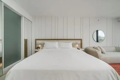 a bedroom with a large white bed and a couch at SOUTH BEACH Stunning Studio in Miami Beach