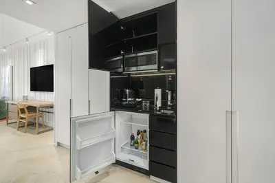 a kitchen with black and white cabinets and an open refrigerator at SOUTH BEACH Stunning Studio in Miami Beach