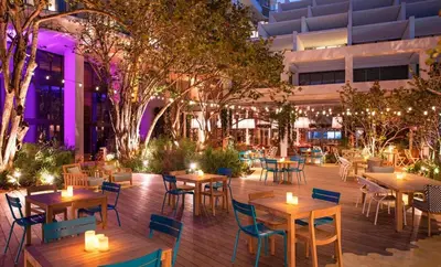 an outdoor restaurant with tables and chairs and lights at SOUTH BEACH Stunning Studio in Miami Beach