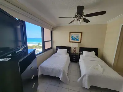 a bedroom with two beds and a flat screen tv at Alexander 1010 in Miami Beach