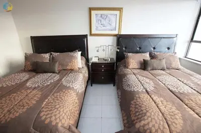 a bedroom with two twin beds and a night stand at Alexander 1010 in Miami Beach