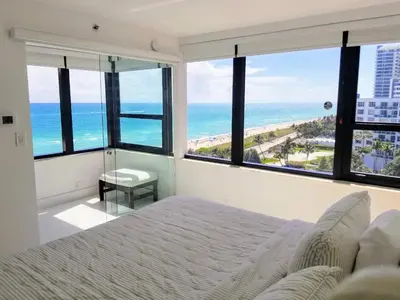 a bedroom with a bed and a view of the ocean at Alexander 1101 in Miami Beach