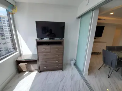 a bedroom with a dresser and a tv in a room at Alexander 1103 in Miami Beach