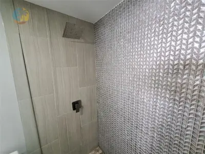 a bathroom with a shower with a tiled wall at Alexander 1104 in Miami Beach