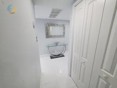a white hallway with a mirror and a white door at Alexander 1104 in Miami Beach