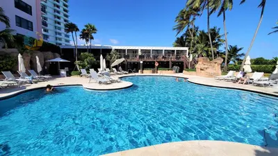 a large swimming pool with chairs and a building at Alexander 1121 in Miami Beach