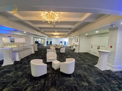 a large room with white chairs and tables and a chandelier at Alexander 1401 in Miami Beach