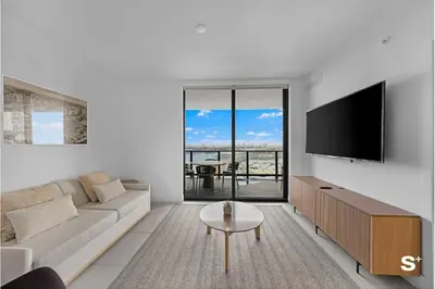 a living room with a couch and a flat screen tv at Luxury Downtown 2-BD Condo with beautiful city views in Miami