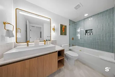 a bathroom with a sink and a toilet and a mirror at Chic Downtown Studio with City Views in Miami