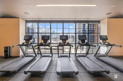 a gym with several treadmills and a large window at Chic Downtown Studio with City Views in Miami