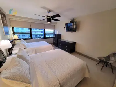 a hotel room with two beds and a flat screen tv at Alexander 1419 in Miami Beach