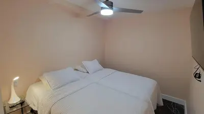 a bedroom with a white bed with a ceiling fan at Alexander 1420 in Miami Beach