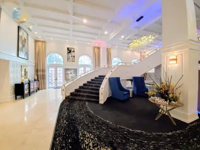 a large lobby with stairs and blue chairs at Alexander 1421 in Miami Beach