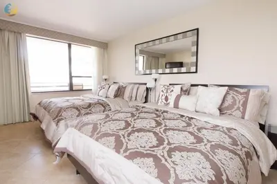 a bedroom with two beds and a mirror at Alexander 1620 in Miami Beach