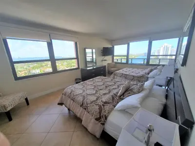 a bedroom with a bed and a couch and windows at Alexander 1620 in Miami Beach