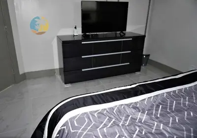 a bedroom with a dresser with a television on it at Alexander 518 in Miami Beach