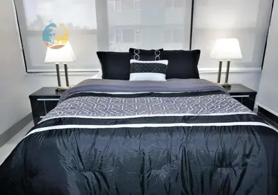 a bedroom with a large black bed with two lamps at Alexander 518 in Miami Beach
